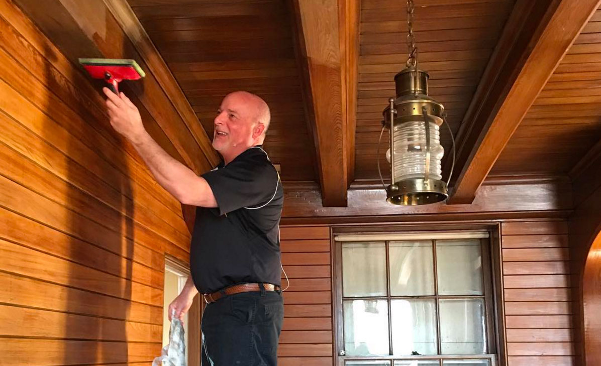 Bob Stephens laying a finishing coat on wooden beams